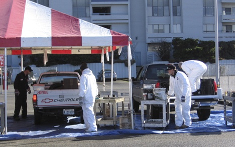 Hazardous waste is unloaded at a King County wastemobile event. Protective gear and materials are used for safety reasons. The wastemobile