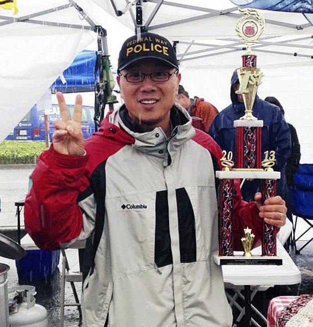 Deputy Police Chief Andy Hwang hoists the first-place trophy.