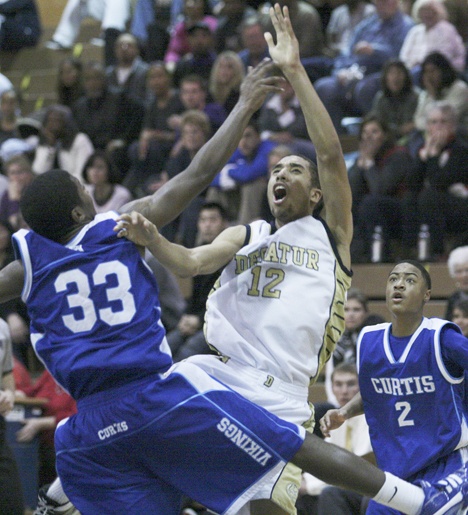 Decatur junior Jerron Smith releases a shot over a Curtis player during Tuesday night's loss to the Vikings