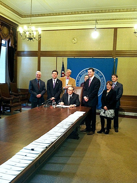 Gov. Jay Inslee signs the Attorney General's open government legislation.