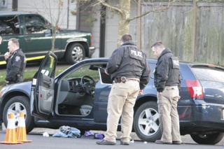 Federal Way police process a Dodge Magnum for evidence Thursday after a shooting near Alderdale Park