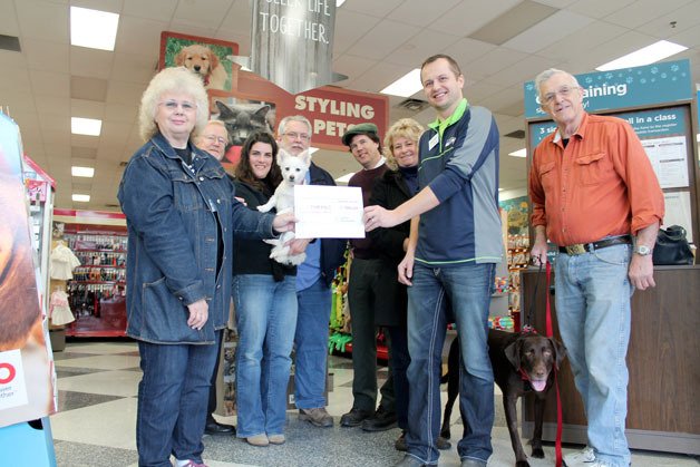 Petco manager Michael Jankowski hands over a check totaling approximately $7