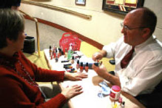 City Manager Neal Beets paints the nails of Tamara Fix