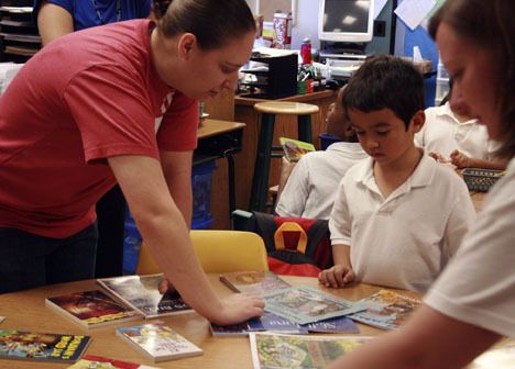 A volunteer helps Andrew Shans pick out at book during the Day of Caring at Mark Twain Elementary. Books for all kindergarten through second grade students were donated by the Page Ahead program.