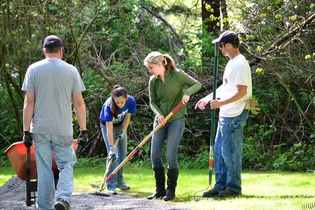 Volunteers rake gravel during Parks Appreciation Day in Federal Way on Saturday.