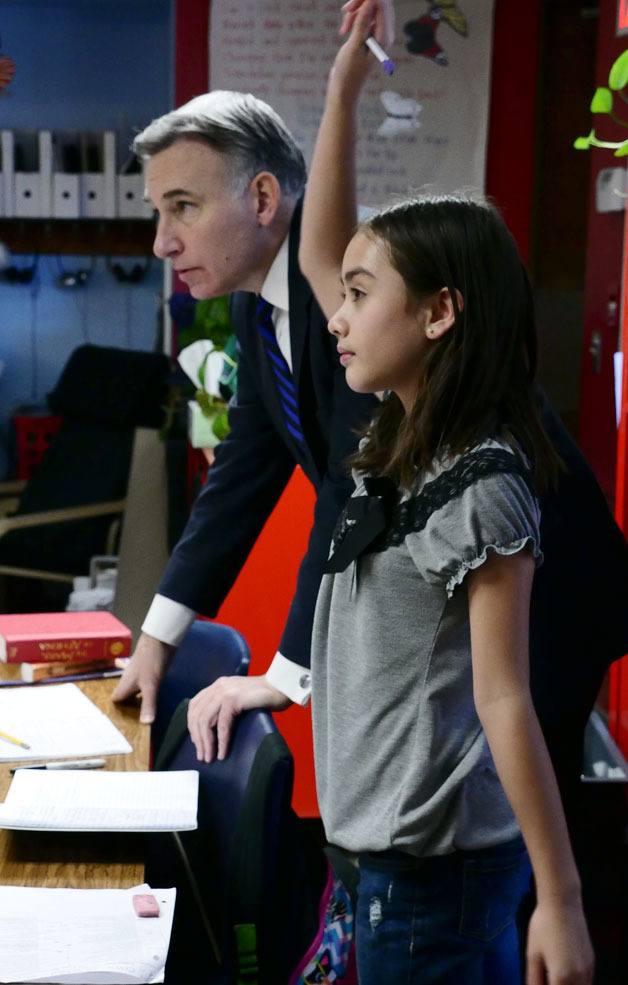 An eager student raises her hand while discussing the Bag Ban Project.