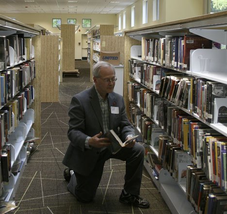 Federal Way resident Mike Lane browses through a book at the newly renovated and expanded Federal Way Regional Library during a sneak peak of the facility Wednesday. The library will reopen to the public June 5.