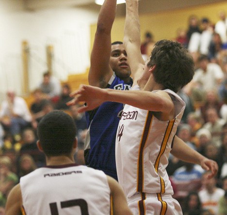 Federal Way senior Cole Dickerson shoots over Jefferson's Spencer Hicks during Thursday's 90-69 Eagle win at TJ. The win ended the Raiders' season and kept the Eagles unbeaten in the SPSL North.