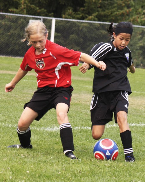 Olivia Chong (right) of the Federal Way United Lightning ‘99-Miyahara girls soccer team battles with a Black Hills FC Red player during a championship at Sunday’s Blast Off Tournament at Saghalie Middle School. Federal Way won the game