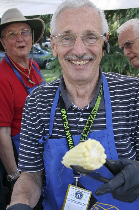 Jim Knapp doles out corn on the cob July 24 at Steel Lake Park for the annual Kiwanis Salmon Bake. The event reeled in about $10