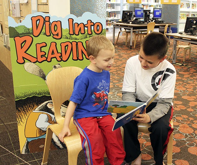 William Markee reads a book to younger brother