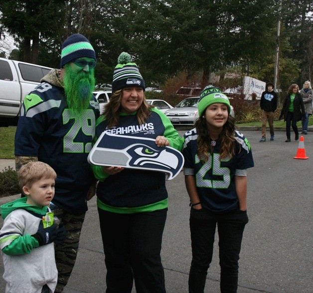 Seahawks fans pose for a photo with fellow fans Brian Wilcox (green beard and face) and his 5-year-old son