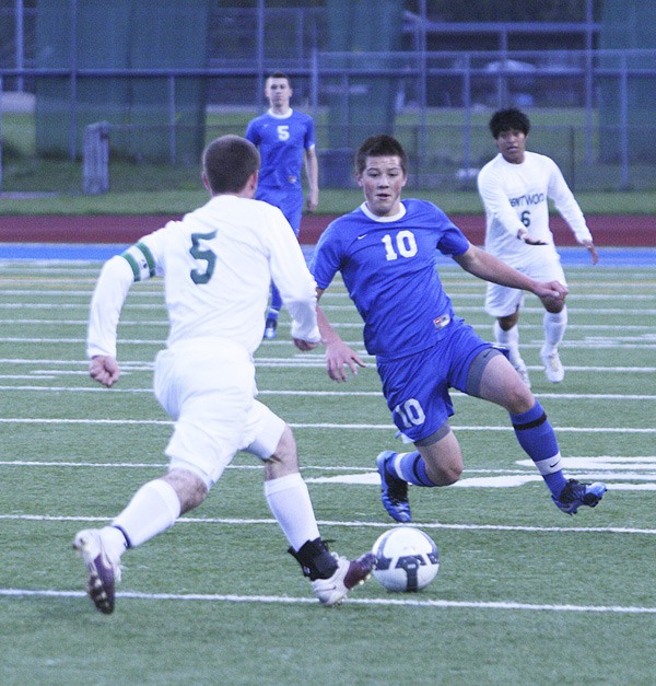 Federal Way senior Colin Kim prepares to slide tackle Kentwood's Daniel Dixon during Wednesday's 1-0 win by the Eagles at the SPSL Tournament in Federal Way.