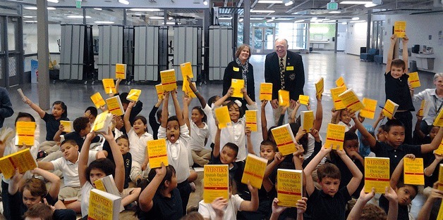 Students in third grade hold up dictionaries that were donated by the Federal Way Service Club Network. The local clubs have donated more than 15