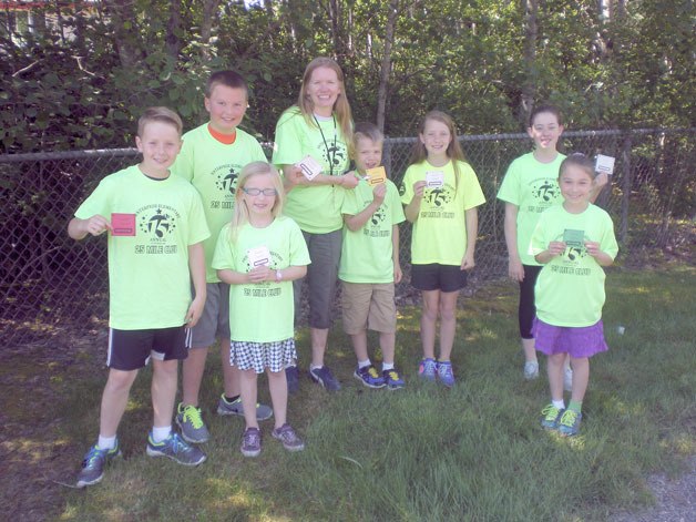 Enterprise Elementary students hold up their punch cards during recess. Students need to reach 25 miles to be part of the 25-Mile Club.