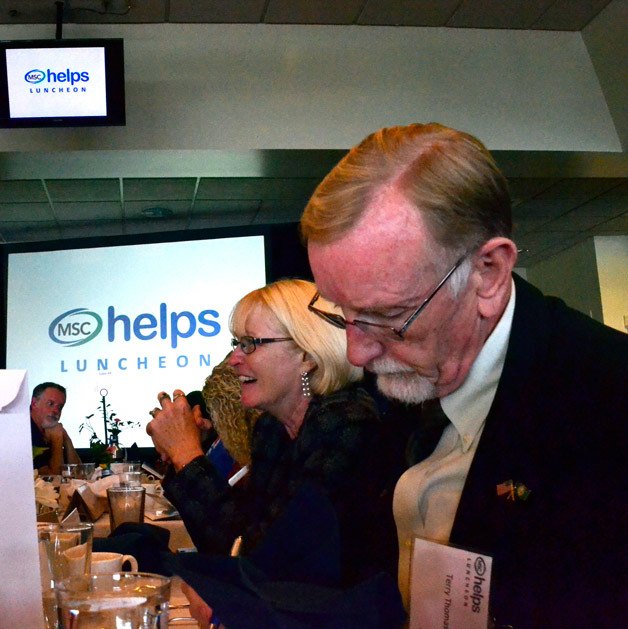 An attendee writes a check during Multi-Service Center’s second annual MSC Helps Luncheon on Oct. 22 at Emerald Downs.