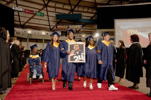 Decatur senior Diamond Cooks (second from right) carries a photo of her twin brother