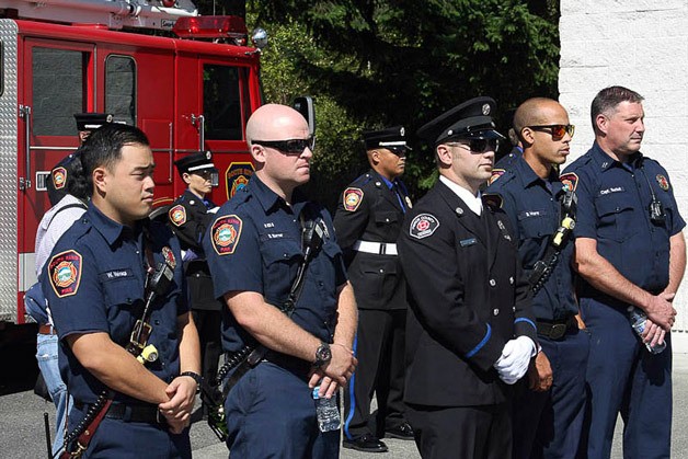 Firefighters with South King Fire and Rescue and other local fire departments listen during a memorial service for the 14th anniversary of 9/11 at South King Fire and Rescue Fire Station 64.