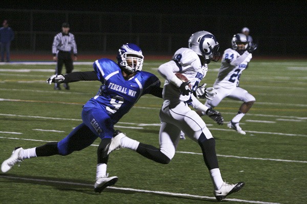 Federal Way senior linebacker Marcus Fielder makes a tackle against Rogers' LaGrant Pegram during Friday night's 46-28 Eagle win in the opening round of the Class 4A State Football Playoffs at Federal Way Memorial Stadium.