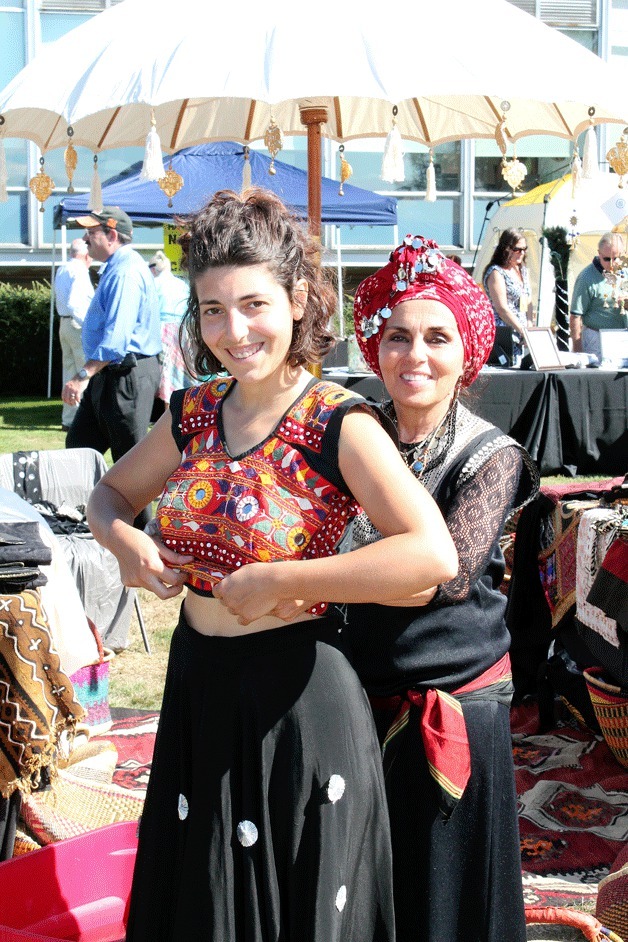 Women selling scarves at FUSION's fundraiser 'Moroccan Mystique' get outfitted in Moroccan garb.