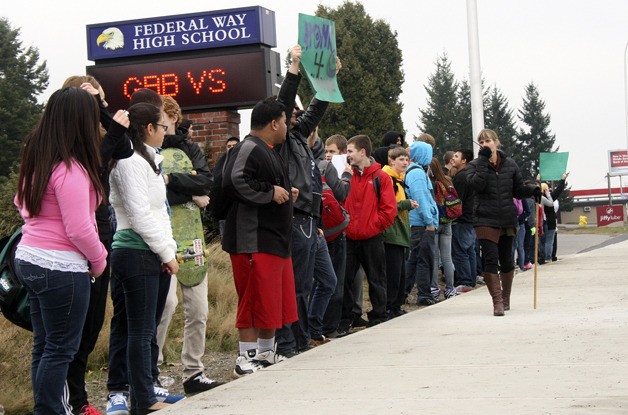 A few dozen students protest peacefully Dec. 6 in front of Federal Way High School as principal Lisa Griebel ensures that order is maintained. Students were required to stay on school property behind the sidewalk in front of the high school.