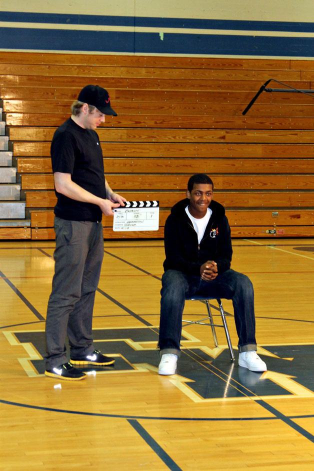 A filming crew member and actor work during the filming of “Reinventing the Patriot” at Federal Way High School in March 2013.