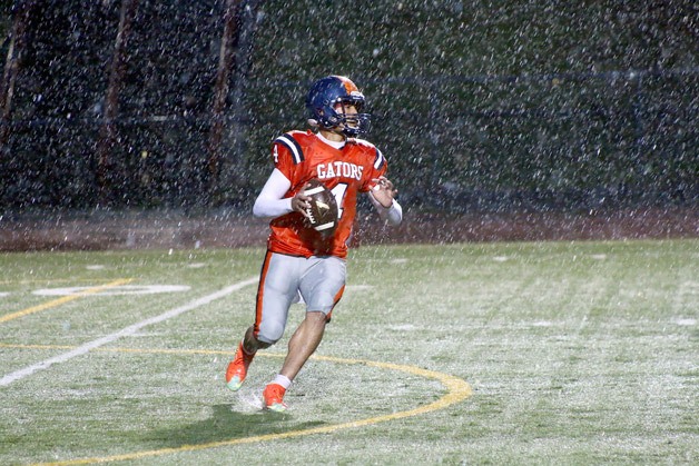 Josiah Talai looks downfield for an open receiver in the heavy rain on Saturday