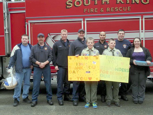 Boys Scouts Aidan and Shaun McCartney (holding signs) brought a basket of goodies to South King Fire and Rescue representatives on May 19 to thank them for their service.