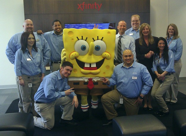 Comcast employees posing with superstar SpongeBob Squarepants at the grand opening of the Federal Way Xfinity Store.