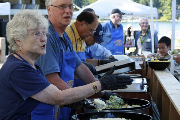 Patti Miller scoops potato salad in the serving line for the Federal Way Kiwanis Club’s annual Salmon Bake