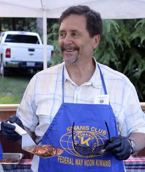 Federal Way resident Mark Knapp serves up salmon at the Federal Way Kiwanis Salmon Bake held July 29 at Steel Lake Park.