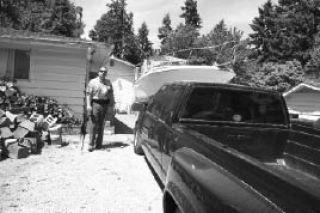 Federal Way resident John Micciche stands in front of his 30-foot boat recently. City code prohibits boats to be stored on property.