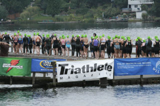 Swimmers stand on the dock at Steel Lake Park Sunday morning in preparation for the start of the U.S. Women’s Triathlon. This is the fifth year in a row that the triathlon was held in Federal Way. (Below) Two women transition from the swim to the biking portion of the event.