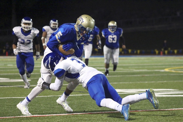 Tahoma’s Jerrel Chapman is wrapped up by Federal Way’s Bobi Sims after catching a pass in the first quarter of the Bears’ 26-22 win on Friday