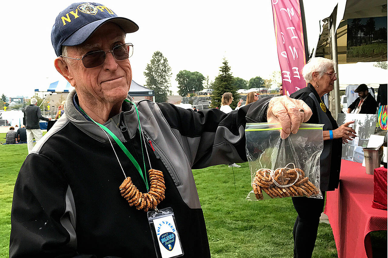 Federal Way Symphony volunteer Bob Kellogg sells pretzel necklaces at the Blues Festival held in 2017 at Town Square Park. (Mirror file photo)