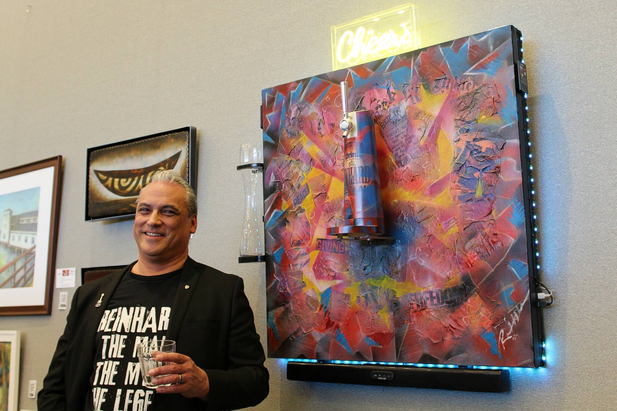 Reinhardt Hollstein is the creator of this unorthodox mixed-media painting, which depicts the fall of the Berlin Wall. Here he poses with the art piece at the first Arts Explosion Festival in 2023. Mirror file photo