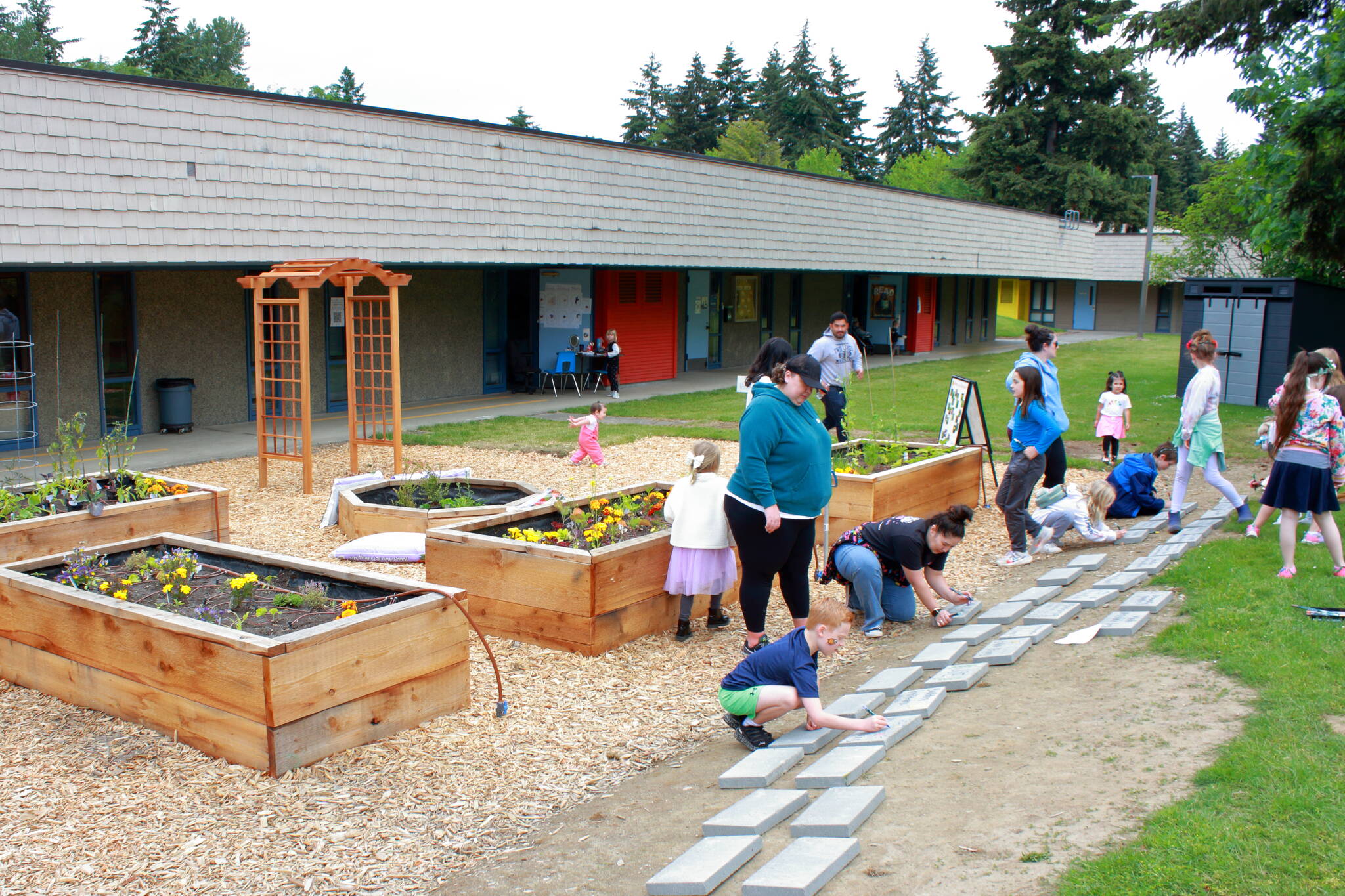 Like other school community gardens, this one features vegetable plants and flowers as well as some native plants. At the grand opening, community members got to put their creative touch on stones in the community garden. Photo by Keelin Everly-Lang / The Mirror