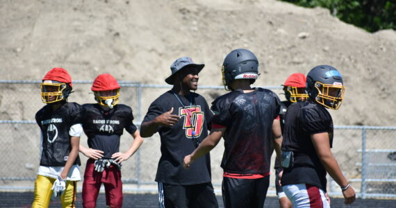 Tremain Mack, new head coach for the Thomas Jefferson High School football team, works with players during summer practices. Ben Ray / The Mirror