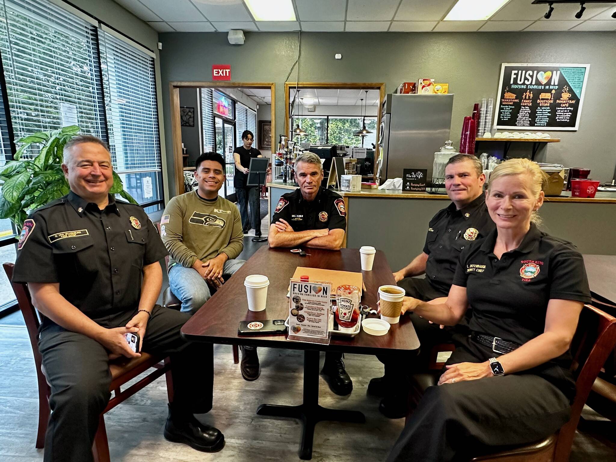 South King Fire Chief Dave Van Valkenburg, left, sits with a guest, District Chief Layne Winter, Deputy Chief Shane Smith and Deputy Chief Lisa Defenbaugh at Poverty Bay Cafe. Photo by Joshua Solorzano/The Mirror