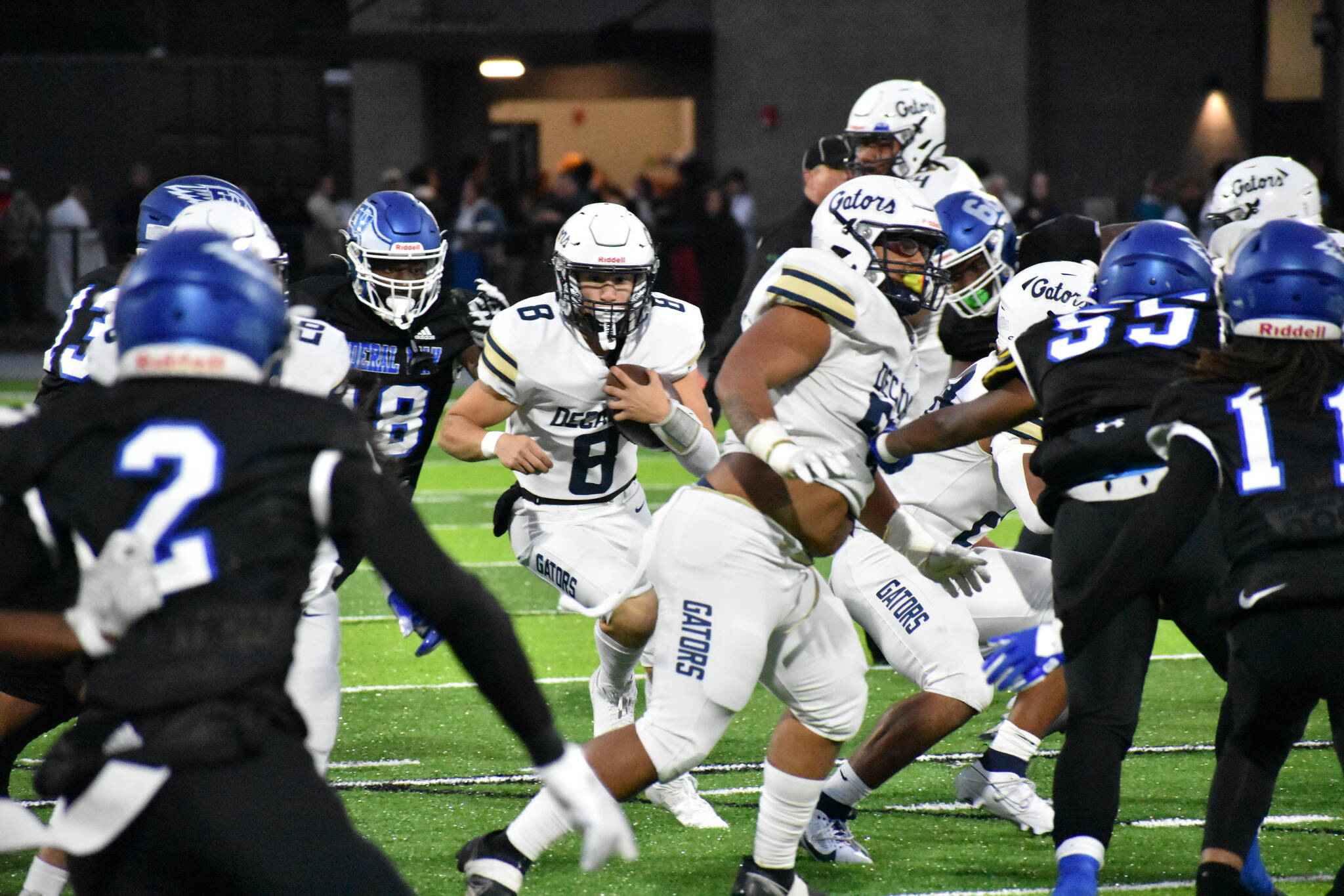 Decatur quarterback Spencer Holloway keeps his eyes down field with the ball in his hands. (Photo by Ben Ray/Sound Publishing)