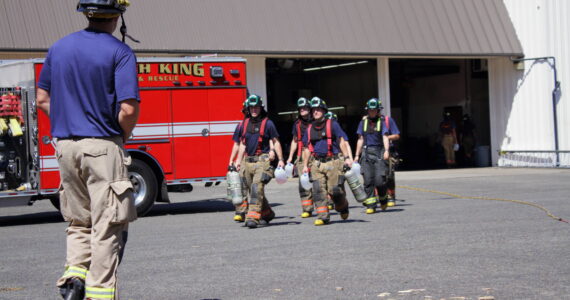 Driver Engineer Brian Jack heads toward a group of newly graduated probationary firefighters during their post-academy training at South King Fire. Photo by Keelin Everly-Lang / The Mirror.