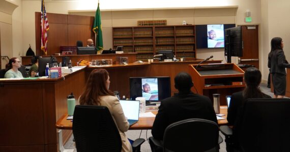 Corniche Washington in the black suit between his defense while the prosecutor delivered her closing statement. Photo by Joshua Solorzano/The Mirror