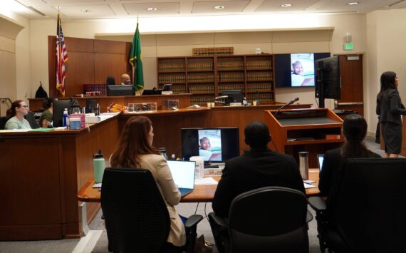 Corniche Washington in the black suit between his defense while the prosecutor delivered her closing statement. Photo by Joshua Solorzano/The Mirror