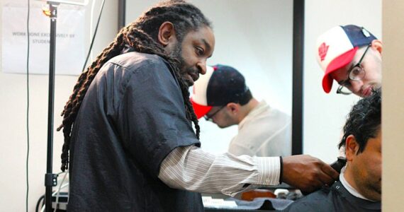 Lamont Styles guides a barber student in finishing up a free haircut for a customer. Life’s Styles offers free haircuts to give back to the community and help students get in plenty of practice. Photo by Keelin Everly-Lang / the Mirror.