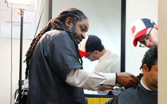 Lamont Styles guides a barber student in finishing up a free haircut for a customer. Life’s Styles offers free haircuts to give back to the community and help students get in plenty of practice. Photo by Keelin Everly-Lang / the Mirror.