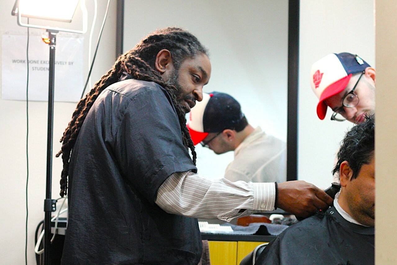 Lamont Styles guides a barber student in finishing up a free haircut for a customer. Life’s Styles offers free haircuts to give back to the community and help students get in plenty of practice. Photo by Keelin Everly-Lang / the Mirror.