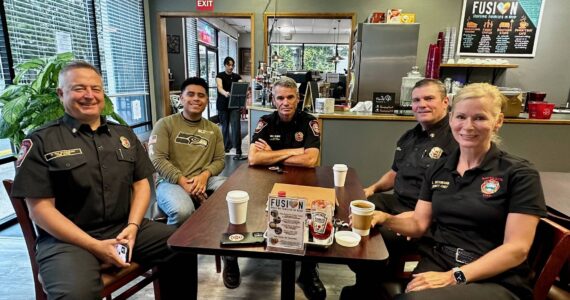 South King Fire Chief Dave Van Valkenburg, left, sits with a guest, District Chief Layne Winter, Deputy Chief Shane Smith and Deputy Chief Lisa Defenbaugh at Poverty Bay Cafe. Photo by Joshua Solorzano/The Mirror