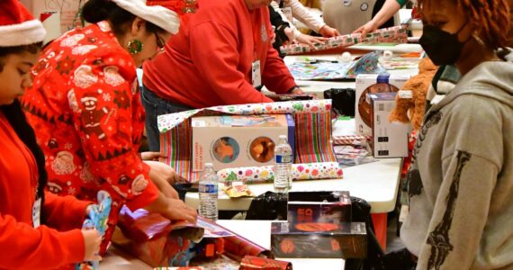 Volunteers partner up with parents and families to wrap presents and ensure that every kid in Federal Way has access to a joyful holiday at the annual Federal Way Cares for Kids event on Dec. 21. Photo by Bruce Honda