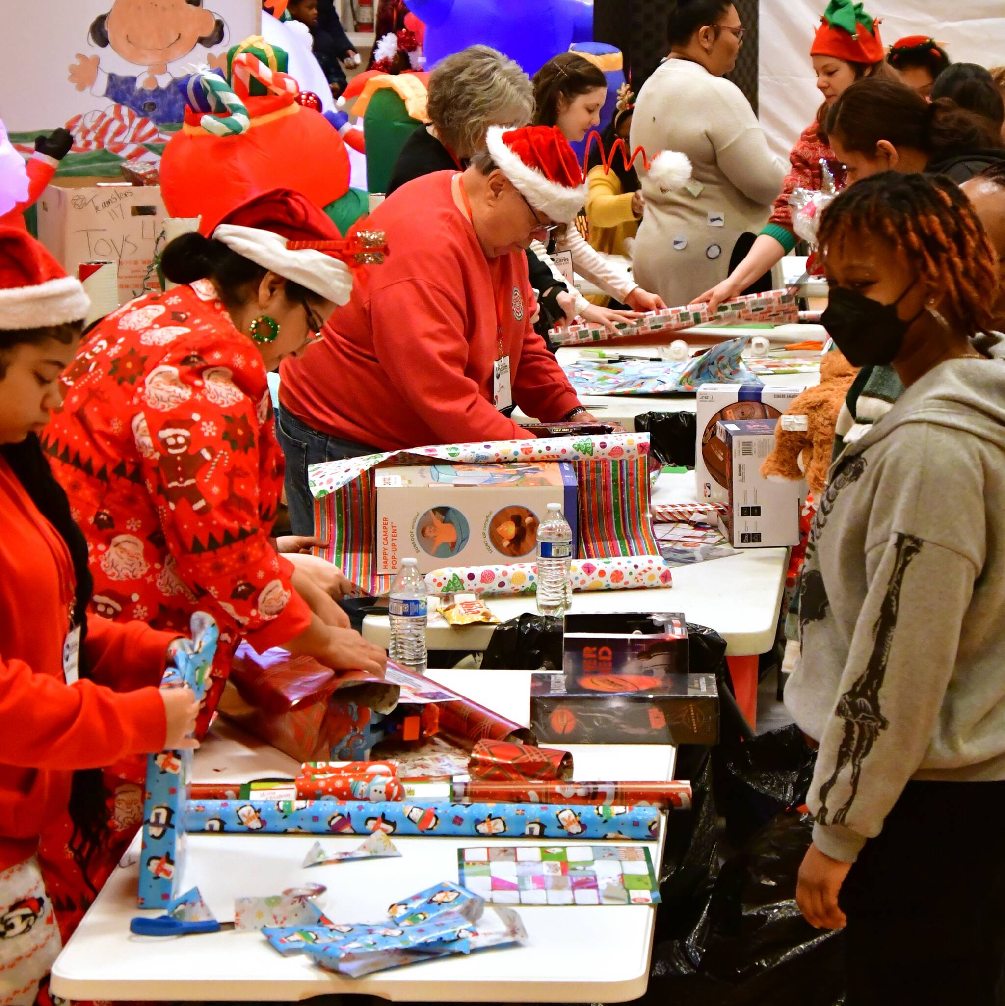 Volunteers partner up with parents and families to wrap presents and ensure that every kid in Federal Way has access to a joyful holiday at the annual Federal Way Cares for Kids event on Dec. 21. Photo by Bruce Honda